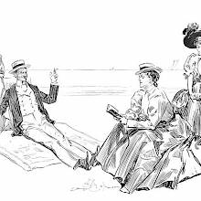 A man is lounging on a beach in the company of fairly indifferent women
