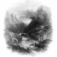 View of the Gap of Dunloe, with a lake in the foreground and mist rising from a mountain