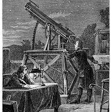 A man standing on a terrace is looking at the sky through a telescope