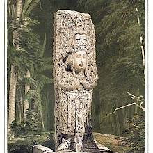 View of a Mayan stone idol standing against a background of woodland