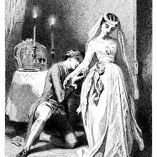 A man kneels beside a woman dressed as a bride and kisses her arm