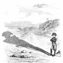 Napoleon stands in a desert where the sun projects his shadow far in front of him