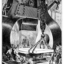 Workers are maneuvering a large piece of metal and guiding it under a large steam hammer