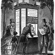 Illuminated newsstand in Paris with people hanging around looking at the newspapers' headlines