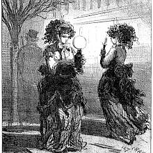 A woman walks in the street carrying an oil lamp and passes another holding a candlestick