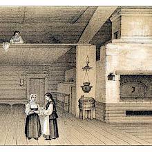 Two women stand in a spacious Russian country interior witha suspended bed area and an oven