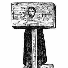 A man is shown standing at a pillory