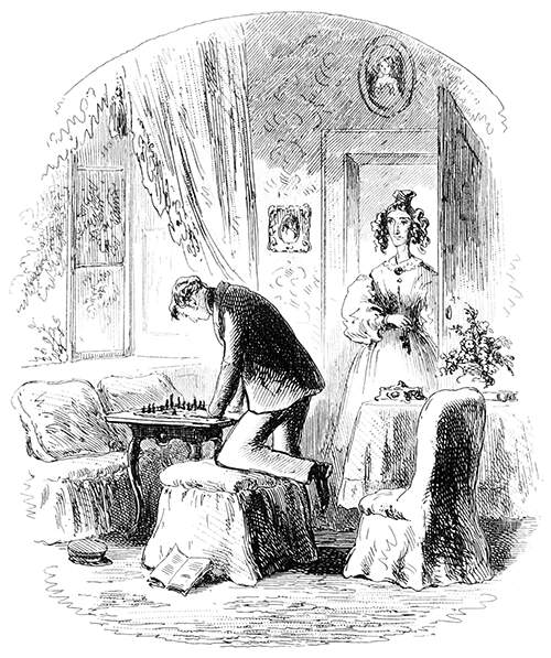 A man with one knee resting on a pouffe leans over a chessboard as a woman enters the room