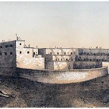 View of a pueblo with terraced structure and a semi-circular wall facing the viewer