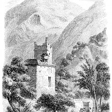 Alpine landscape with mountain peaks, steep slopes, and a building topped with a damaged tower