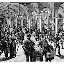 View of the Gare Saint-Lazare waiting hall busy with passengers and lit by electric lights