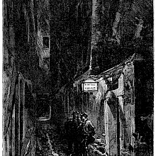 Two men are standing the rain at night, under the lantern of a seedy hotel