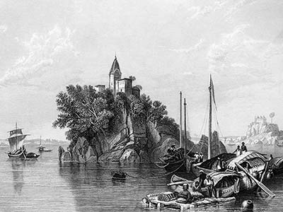 View of a rocky island on the Ganges, topped by a tower, with boats in the foreground