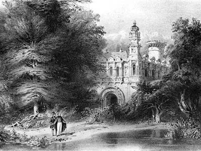 Two men stand on the bank of a pond, with a fancy castle visible behind lush trees in the background