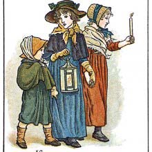 A woman and her two children are out carrying a candle and a lantern on All Saints' Day