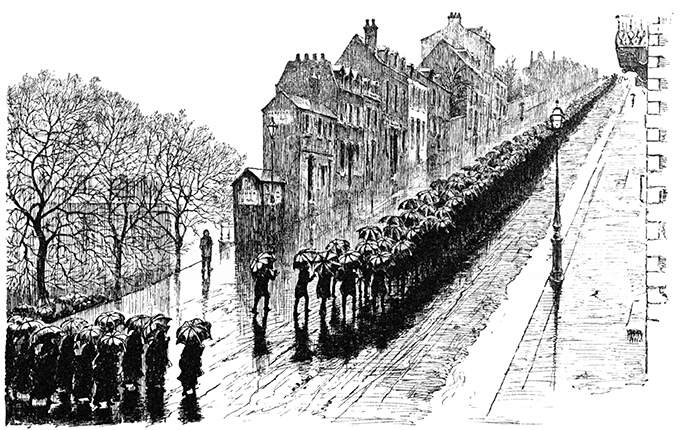 A funeral procession moves up a long and steeply sloping street in the rain