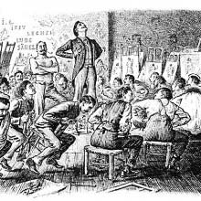 A man stands laughing in the middle of students straddling on their chairs