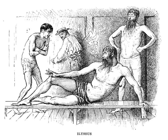 A bearded man in swimming trunks is reclining on a bench in a locker room
