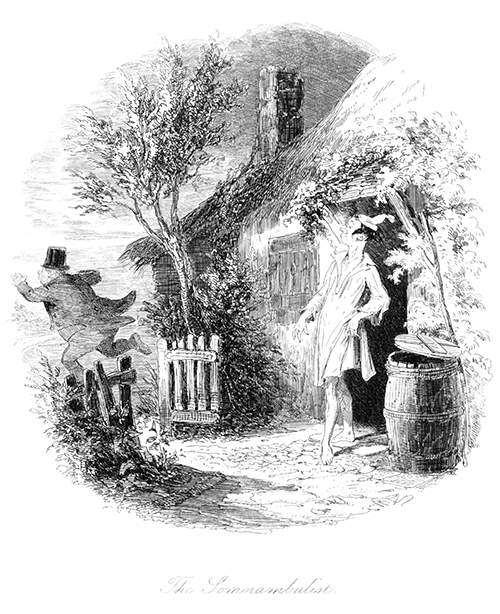 A man stands in a night shirt and cap in front of a cottage door