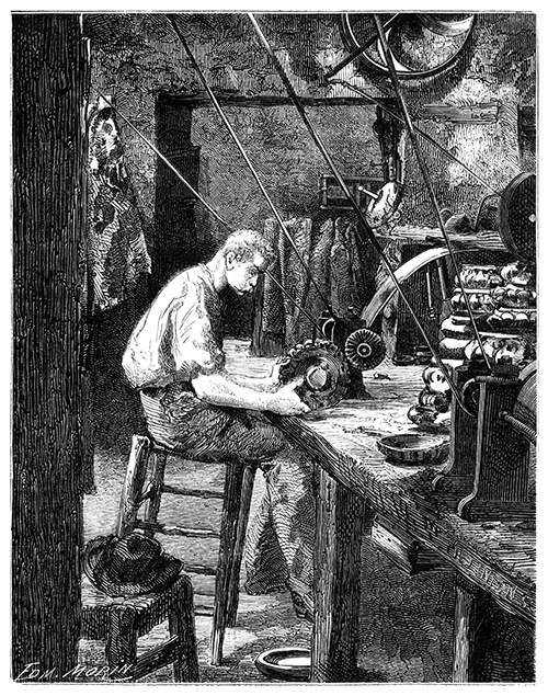 A polisher is sitting at a workbench operating a buff wheel