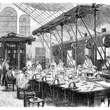 Silversmith's workshop where workers can be seen at a large collective workbench