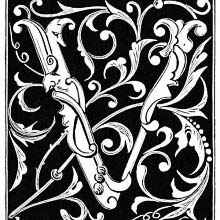 Capital V decorated with foliated design on a black background