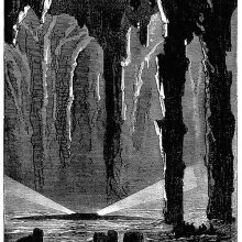 A submarine surfaces in a sea cave showing rocky pillars and concretions
