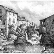 Waterfall cascading into a pond surrounded by a water mill and various buildings