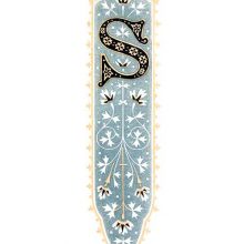 Ornamental initial S with foliated design on blueish-gray background and orange border.