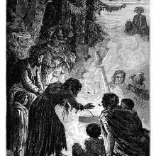 A group of people is gathered at night around a campfire as a man on hoseback approaches