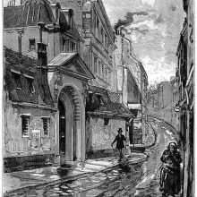 A shabby-looking woman walks down a street, followed by a man on the opposite pavement