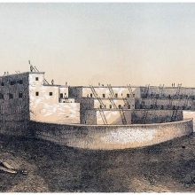 View of a pueblo with terraced structure and a semi-circular wall facing the viewer