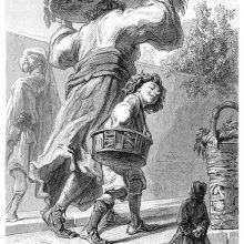 Gulliver stands on a street as a boy and his mother, carrying a tray on her head, pass him by