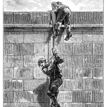 A man climbs down on a rope from the top of a wall, followed by his companion