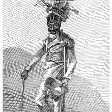 A man with a crutch and a cane smiles while wearing the scale model of a ship on his hat