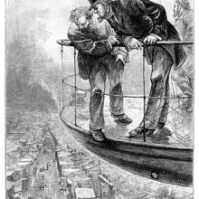Two men standing on the deck of an aircraft lean over the railing to look at the city below them