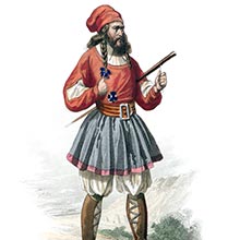 A Sardinian man wearing the traditional costume of Tresnuraghes stands on a hill