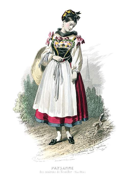 An Alsatian girl in traditional dress stands looking down at a cross on the side of the path
