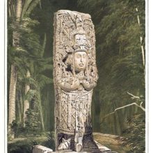 View of a Mayan stone idol standing against a background of woodland