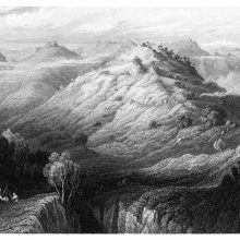 Bird's eye view of a mountainous landscape with a cone-shaped hill standing at its center