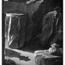A man crouches at the bottom of a hut as the shadow of a man approaching can be seen on the ground