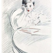 A boy sitting at a table has stopped drawing and leans on his elbow