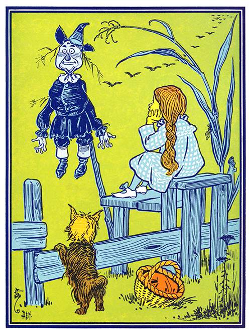A young girl is sitting on a stile by a cornfield and looks at a scarecrow on a stake