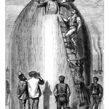 A man appears through an opening at the top of a cannon shell-shaped rocket, greeted by his friends