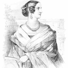 Portrait of a young woman looking to the side with a fan in her hand and wearing elaborate buns