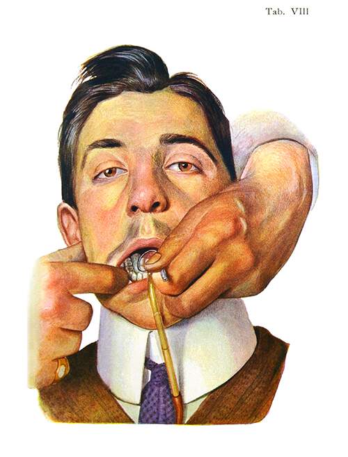 The hands of a dentist are seen operating a suction device in the mouth of a young man