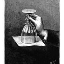 A hand holds a glass upside down as the water inside is kept from running out by a sheet of paper