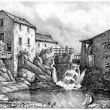 Waterfall cascading into a pond surrounded by a water mill and various buildings