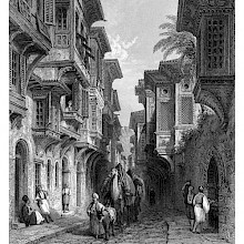 Street in Izmir showing balconies projecting over the sidewalks and a merchant leading camels